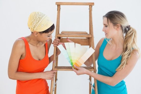 Deux artistes examinent un nuancier de couleurs près d'un escabeau en bois pour apprendre comment prouver qu'une œuvre est peinte à la main pour rassurer les collectionneurs.