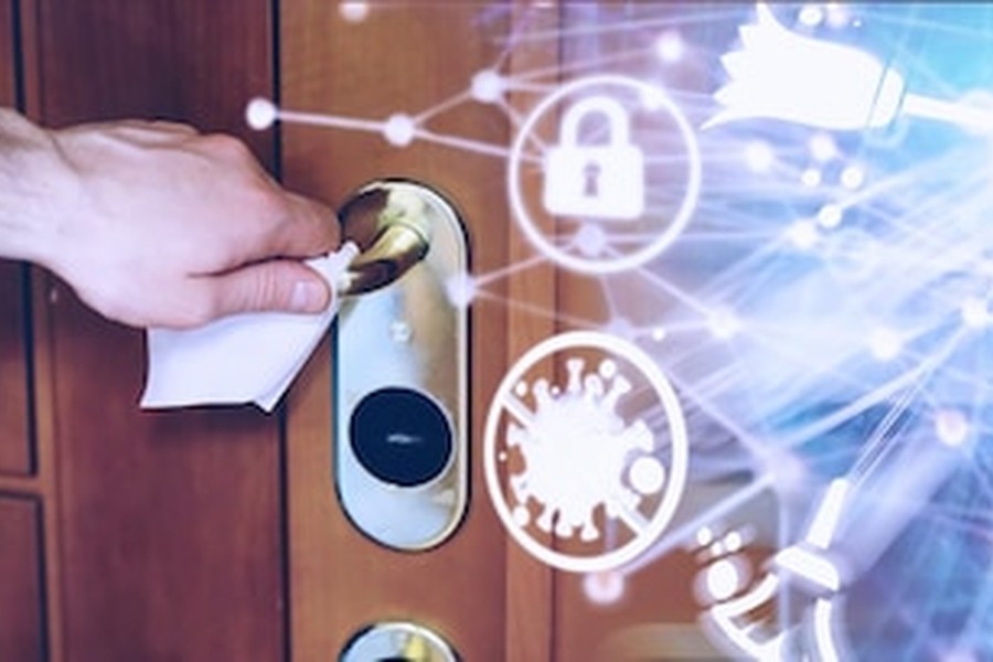 Une main actionne une poignée de porte moderne équipée de serrures connectées et assurance habitation : les nouvelles exigences de sécurité en 2026.