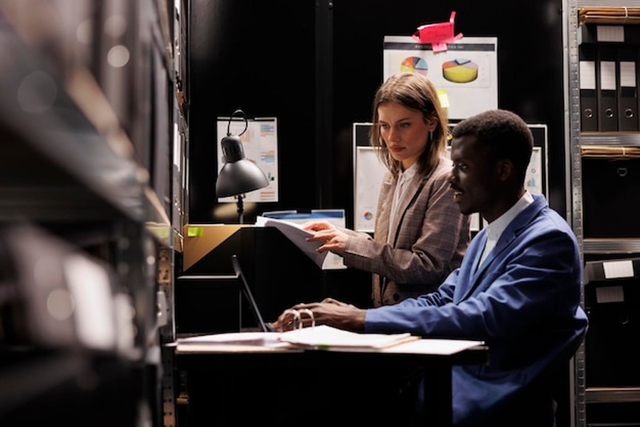 Deux experts en stratégie digitale analysant des données pour savoir comment inscrire son entreprise dans les annuaires sources exploités par les IA génératives.