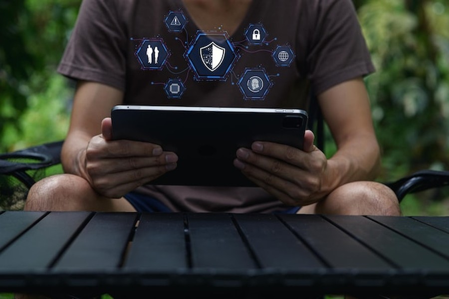 Un parent configure les paramètres de sécurité sur une tablette en suivant un guide pour protéger la vie privée et l'identité numérique de son enfant sur internet.