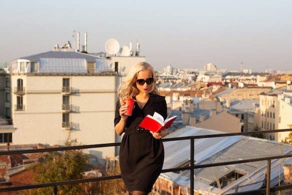 Une voyageuse profite de la brise sur un toit-terrasse scandinave, une étape clé pour savoir comment organiser un voyage de 'Coolcation' en Europe du Nord pour éviter les fortes chaleurs.