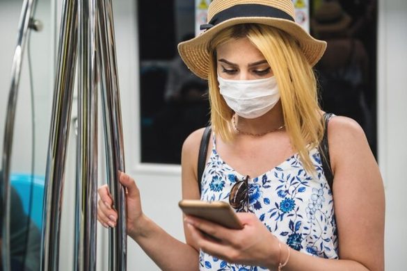 Une voyageuse consulte son smartphone dans les transports, illustrant comment voyager sans passeport physique : guide complet de l'identité numérique et des contrôles biométriques 2026.