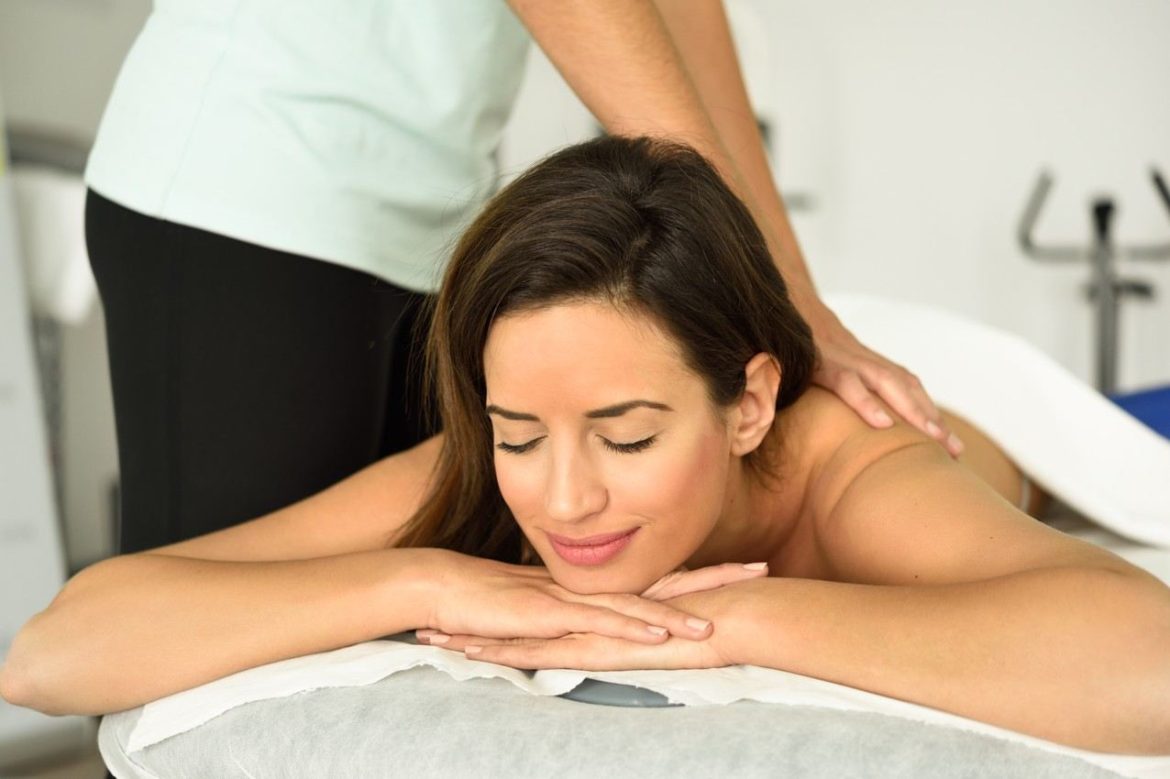 Une femme allongée yeux fermés recevant un massage contre fatigue chronique et épuisement au niveau du dos.